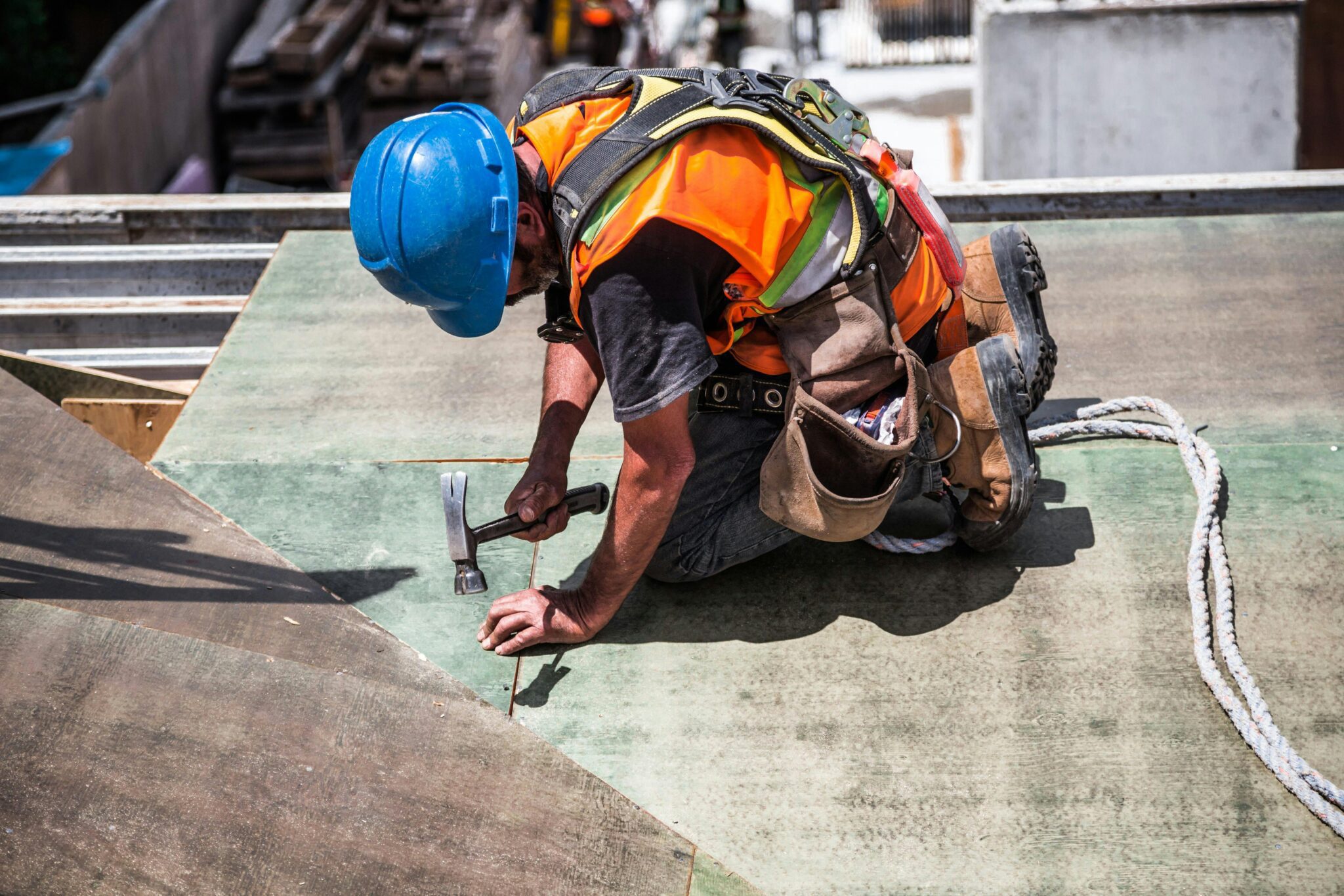 Construction worker hammering nails into timber decking