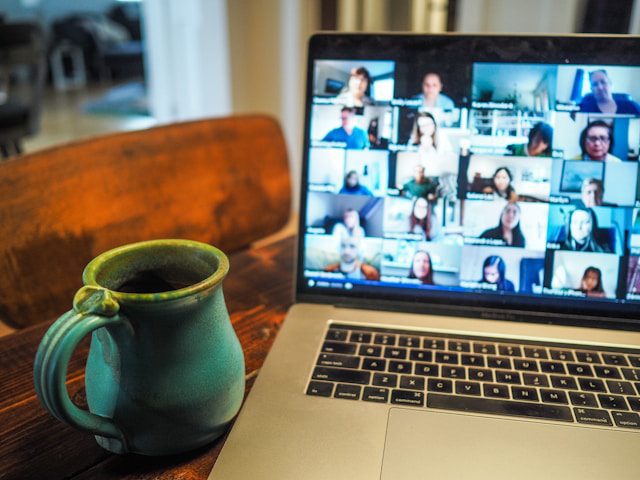 Laptop showing online video call with a coffee mug on a table