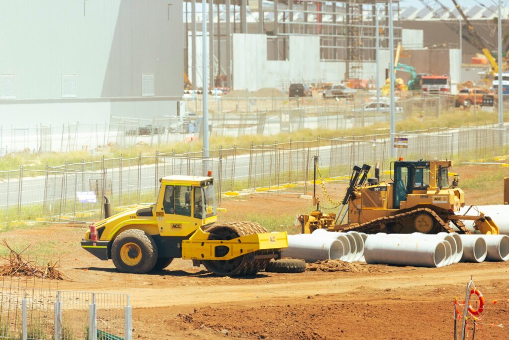 Large construction site with rollers, and site vehicles.