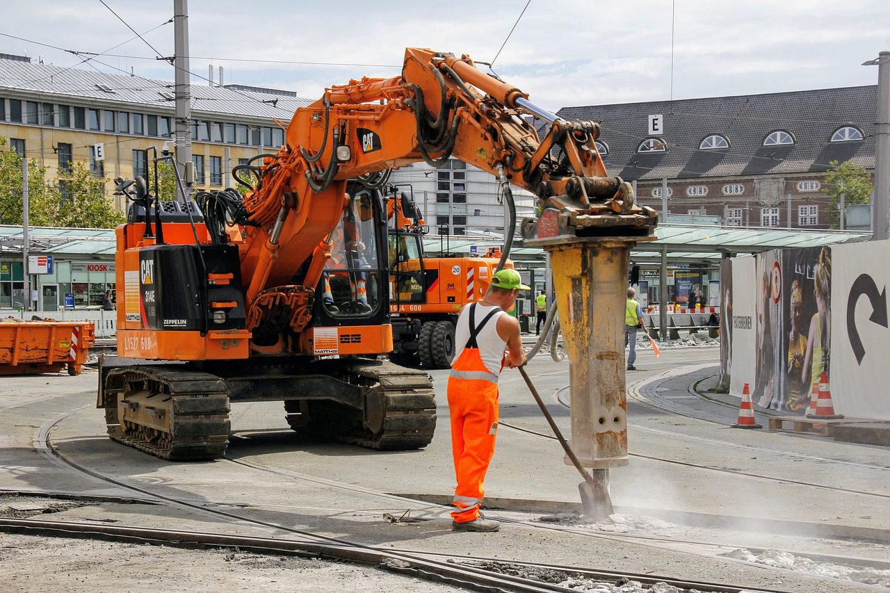 Roadworks with excavator and jackhammer in urban area