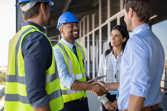 Construction professionals in safety gear shaking hands on site, representing employment opportunities after White Card certification.