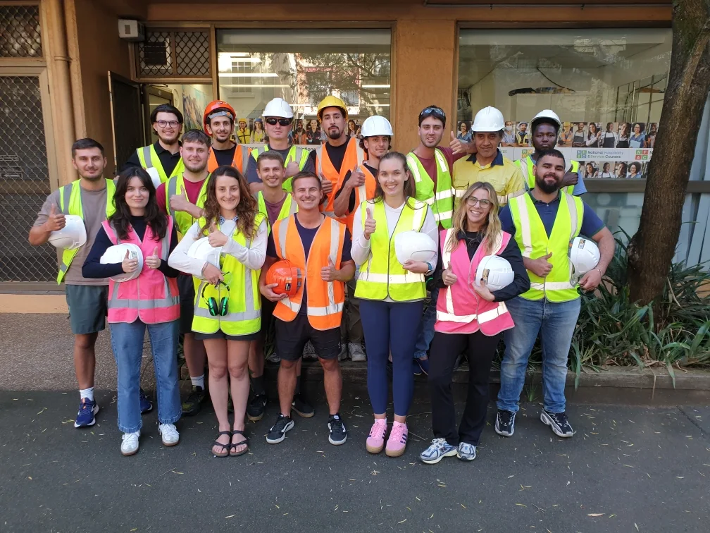 Group of White Card students wearing high-vis vests outside a training centre.