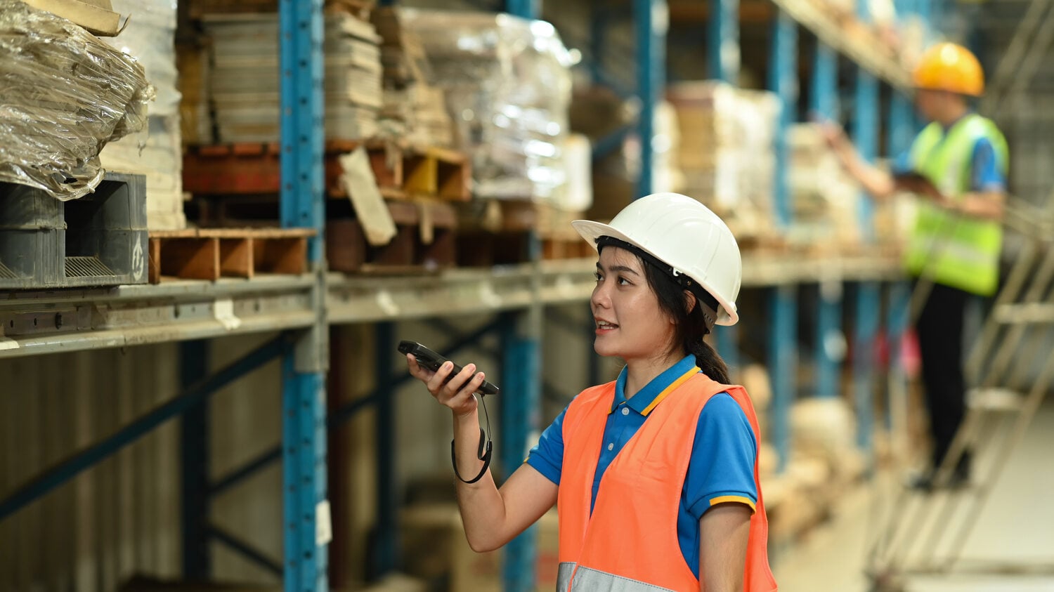 Woman in hi-vis gear doing a stock check at a mine site warehouse