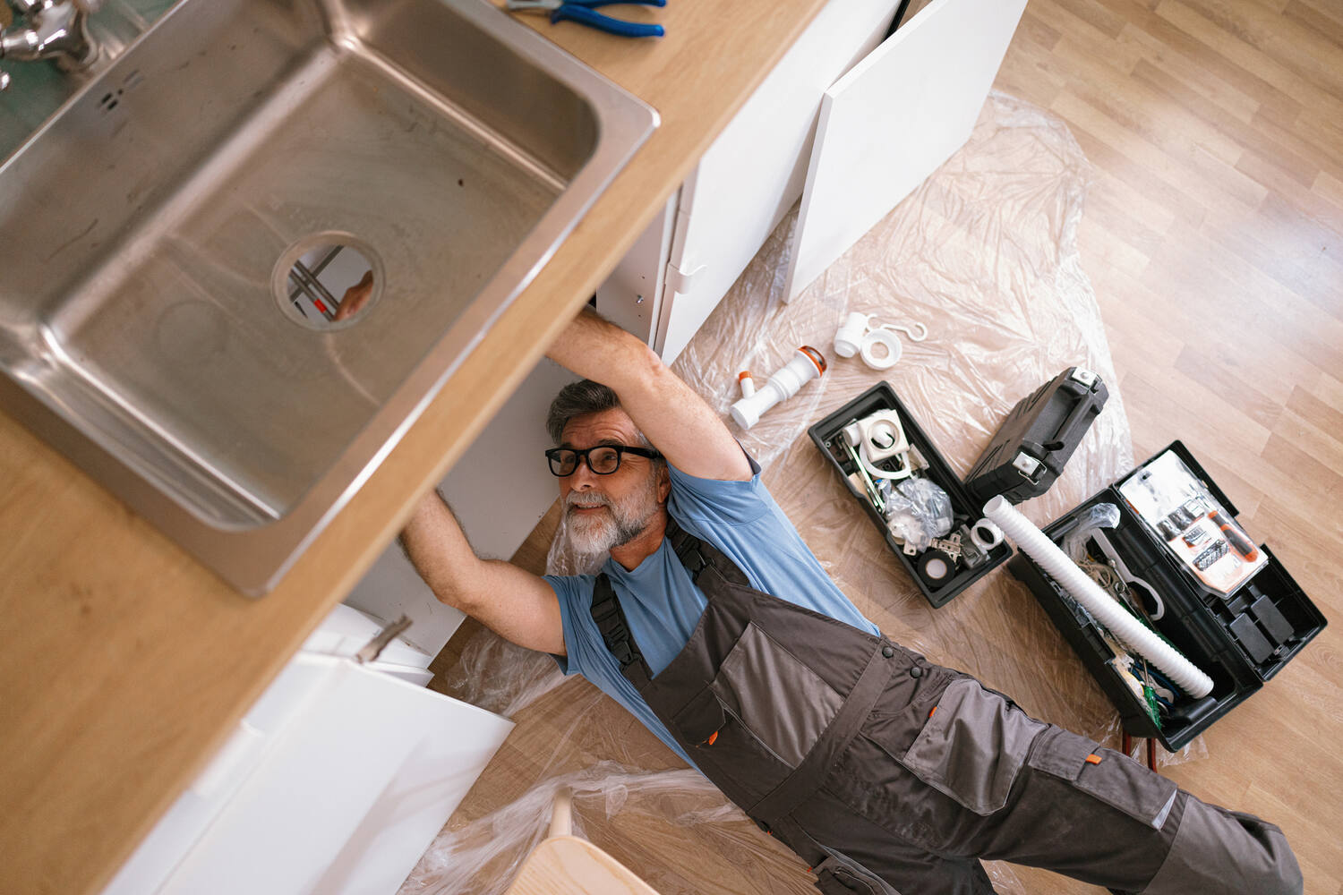 plumbing specialist check under a sink for a leak